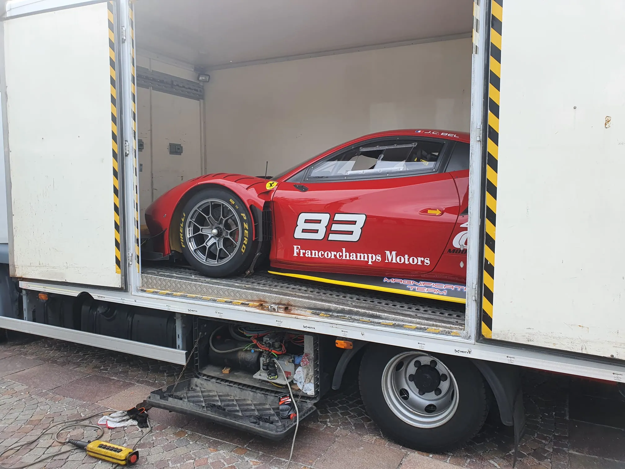 Ferrari da corsa numero 83 Francorchamps Motors nel furgone Lory